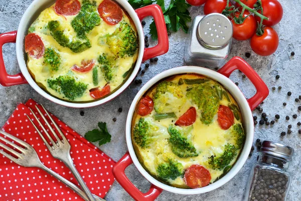 Gryta med broccoli och tomater på en konkret bakgrund. — Stockfoto