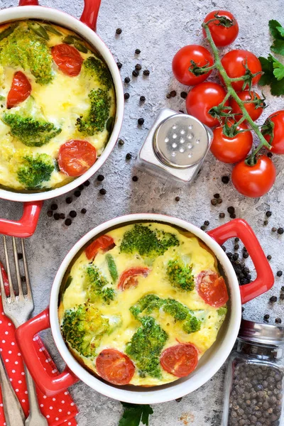 Gryta med broccoli och tomater på en konkret bakgrund. — Stockfoto