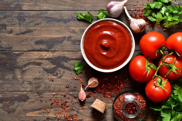 Tomato ketchup sauce with spices and pepper. View from above. — Stock Photo, Image