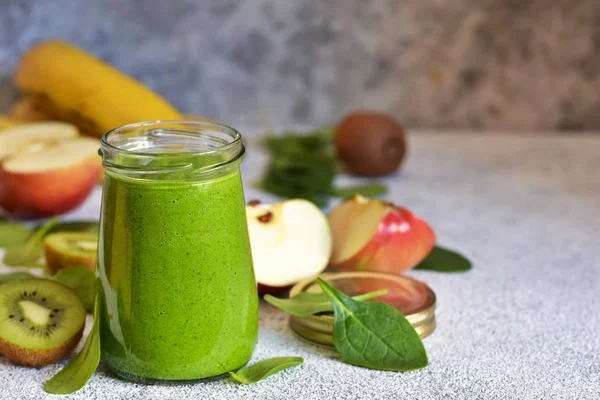 Muz, kivi, elma ve ıspanak ile yeşil smoothie bir konkret üzerinde