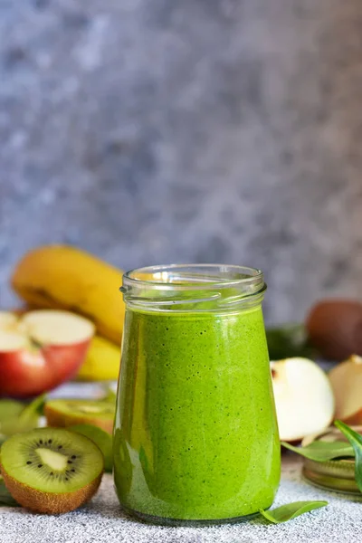 绿色冰沙与香蕉，奇异果，苹果和菠菜在混凝土 — 图库照片