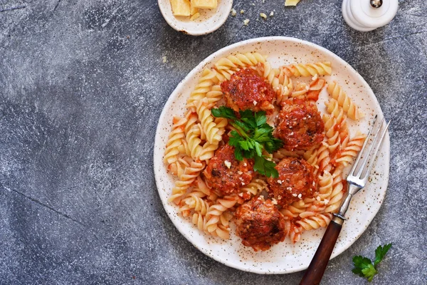 Italian pasta with meat balls, tomato sauce and parmesan