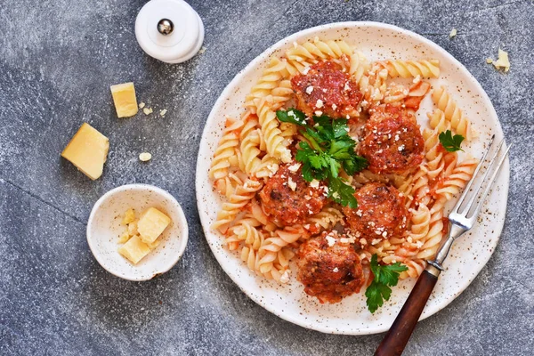 Итальянская паста с мясными шариками, томатным соусом и пармезаном — стоковое фото