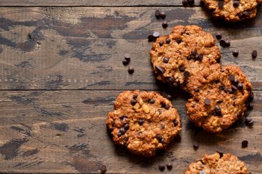 Ahşap bir arka plan üzerinde çikolata damla ile yulaf ezmesi çerezleri. 