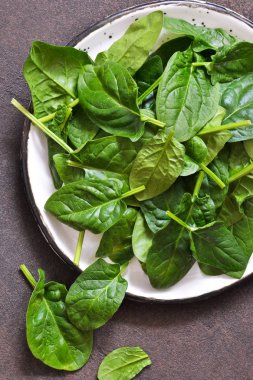 Beton arka planda taze, genç yeşil ıspanak.