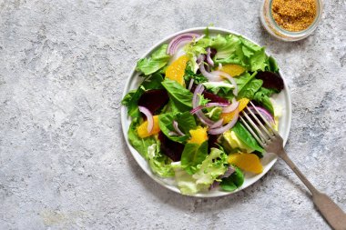 Mutfak masasında portakal, pancar ve sos ile karışık salata. Organik Gıda. Vegan.