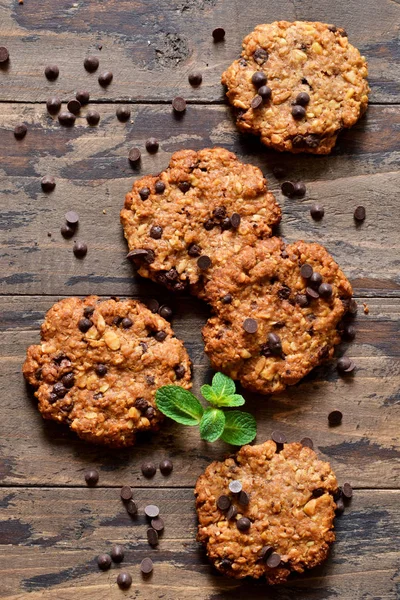 Oatmeal cookies with chocolate drops on a wooden background.