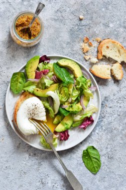 Bir concr üzerinde ıspanak, avokado, yumurta pulluk ve sos ile taze salata
