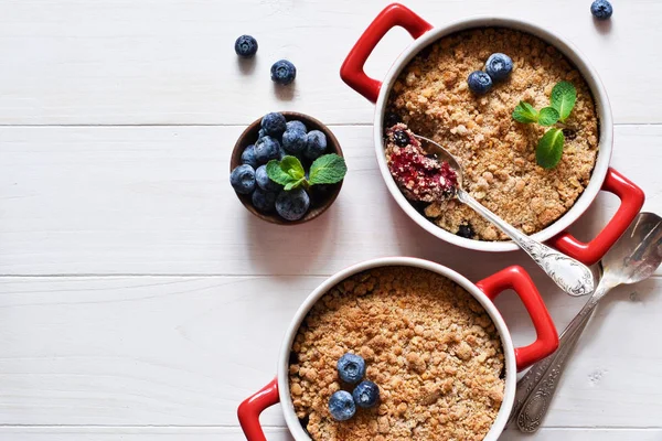 Beyaz bir mutfak masasında yaban mersini ile crumble. abo'dan görünüm — Stok fotoğraf