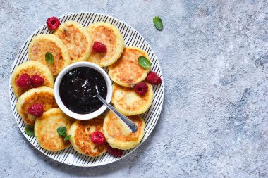 Kahvaltı zamanı. Kahvaltı için ahududu sosu ile peynir kekler 