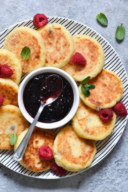 Kahvaltı zamanı. Kahvaltı için ahududu sosu ile peynir kekler 