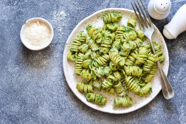 Beton arka plan üzerinde pesto ve parmesan ile Makarna. 