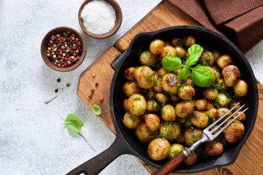 Kızarmış, tavada fesleğenli genç patatesler. Yukarıdan görüntüle.