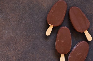 Çikolatalı dondurma. Beton arka planda buzlu şeker. Üstte görüntü.