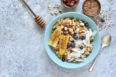 Karamel, muz, yaban mersini ve hindistan cevizi cipsi ile yulaf ezmesi bir