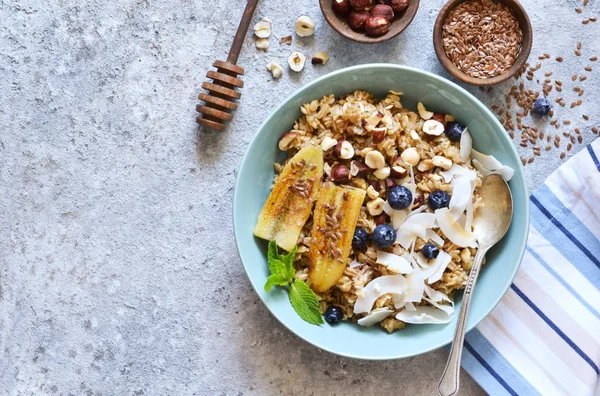 Oatmeal with caramel, banana, blueberries and coconut chips on a