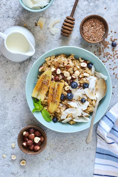 Oatmeal with caramel, banana, blueberries and coconut chips on a