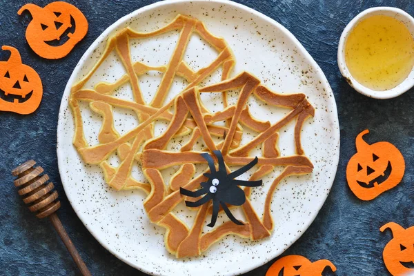 Halloween food for kids. Funny pancakes - spider web and spider.