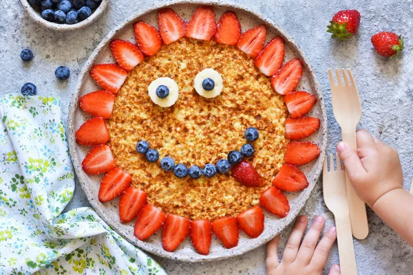 Makanan untuk anak-anak. Funny sun with a smile pancake with berrie — Stok Foto