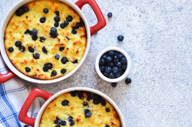 Mutfak masasında yaban mersini ile süzme peynir güveç. 