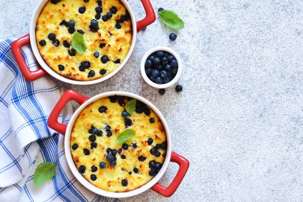 Casseruola di fiocchi di latte con mirtilli sul tavolo della cucina . — Foto Stock