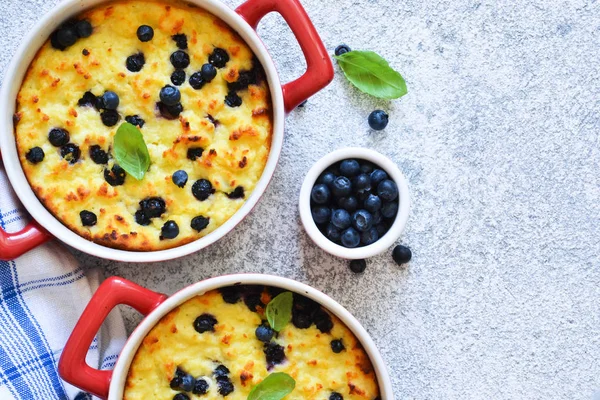 Casseruola di fiocchi di latte con mirtilli sul tavolo della cucina . — Foto Stock