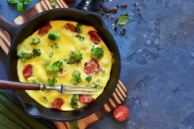 Masada dökme demir tavada sebzeli omlet.