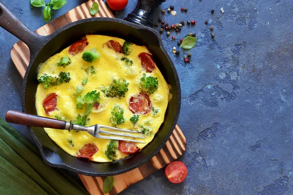 Omelet con verdure in una padella di ghisa sul tavolo . — Foto Stock