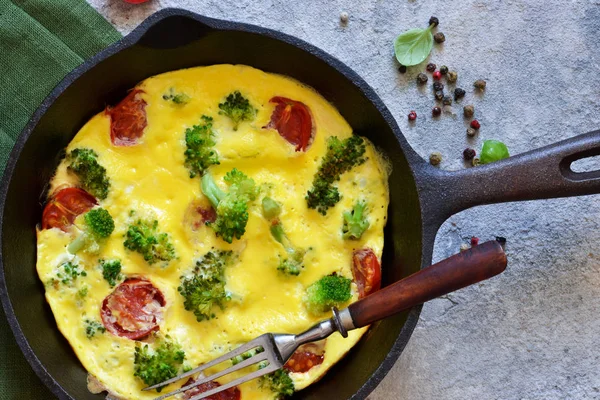 Omelet con verdure in una padella di ghisa sul tavolo . — Foto Stock