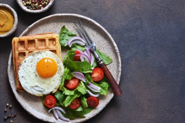 Bir tabakta kahvaltı için yumurta ve salata ile Belçika waffle 