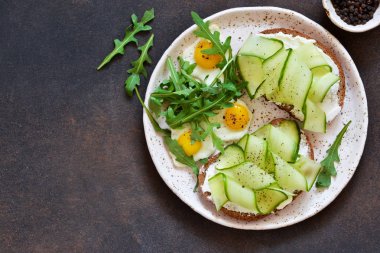 Öğle yemeği vakti. Peynir, çubuk ve salatalık ile ekmek tost