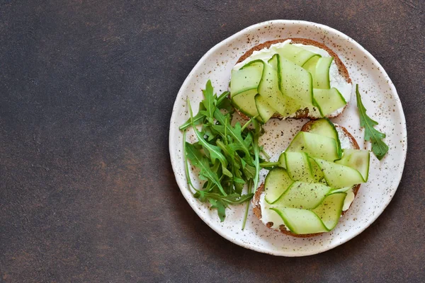 Lunch time. Bread toast with cheese, chopstick and cucumber