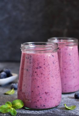 Mutfak masasında yaban mersini ile Mor smoothies. 