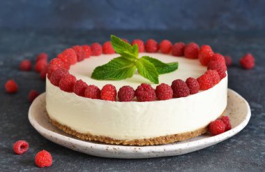 Bir taş arka plan üzerinde ahududu ile Vanilyalı cheesecake. Yeni Y