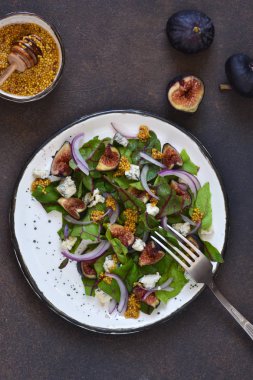 Sıcak bir arka planda incirli ve mavi peynirli vitamin salatası..