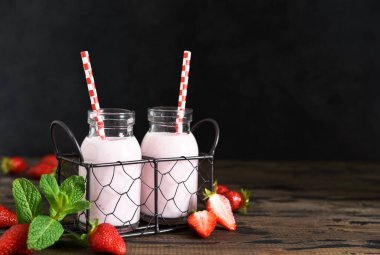 Ahşap arka planda çilek ve yoğurtlu meyve suları. Detox menüsü.