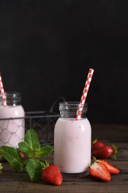 Ahşap arka planda çilek ve yoğurtlu meyve suları. Detox menüsü.