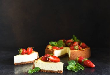 Çilekli cheesecake ve koyu arkaplanlı nane şekeri. New York peynirli keki. Reklamcılık. Restoran menüsü.