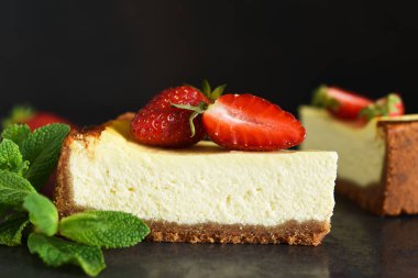 Çilekli cheesecake ve koyu arkaplanlı nane şekeri. New York peynirli keki. Reklamcılık. Restoran menüsü.