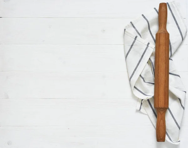 Wooden rolling pin with a napkin on a concrete background with a place for a recipe. View from above. Flatly