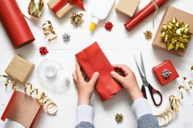 Bir çocuğun elleri hediyeyi paketliyor. Yukarıdan bak. Adım adım fotoğraf. Dördüncü Adım