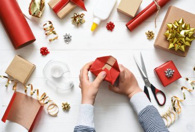 Bir çocuğun elleri hediyeyi paketliyor. Yukarıdan bak. Adım adım fotoğraf. Beşinci adım