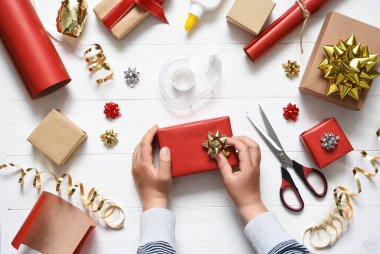 Bir çocuğun elleri hediyeyi paketliyor. Yukarıdan bak. Adım adım fotoğraf. 8. adım..