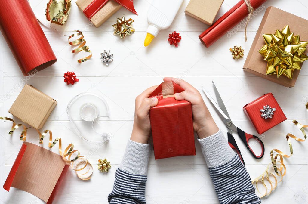 Children's hands of a boy are wrapping a gift. View from above. Step by step photo. Step Six