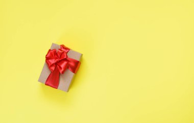 Sarı arka planda kırmızı kurdeleli ve hediyeli bir sürü kutu. Yukarıdan görüntüle.