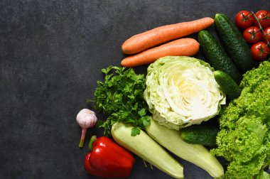 Siyah taşlı arka planda taze, organik sebzeler. Yukarıdan bak. Biyolojik sebze.