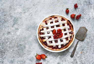 Beton zemin üzerinde kirazlı tart, üst görünüm.