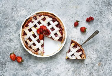 Beton zemin üzerinde kirazlı tart, üst görünüm.