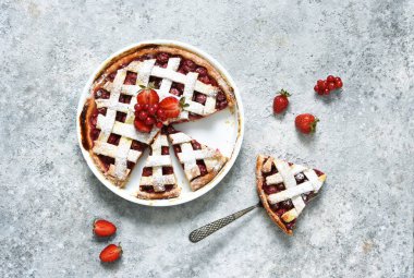 Beton zemin üzerinde kirazlı tart, üst görünüm.