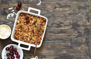 Tahta bir arka planda fındıklı, hindistan cevizli ve böğürtlenli tahıl. Üst görünüm.